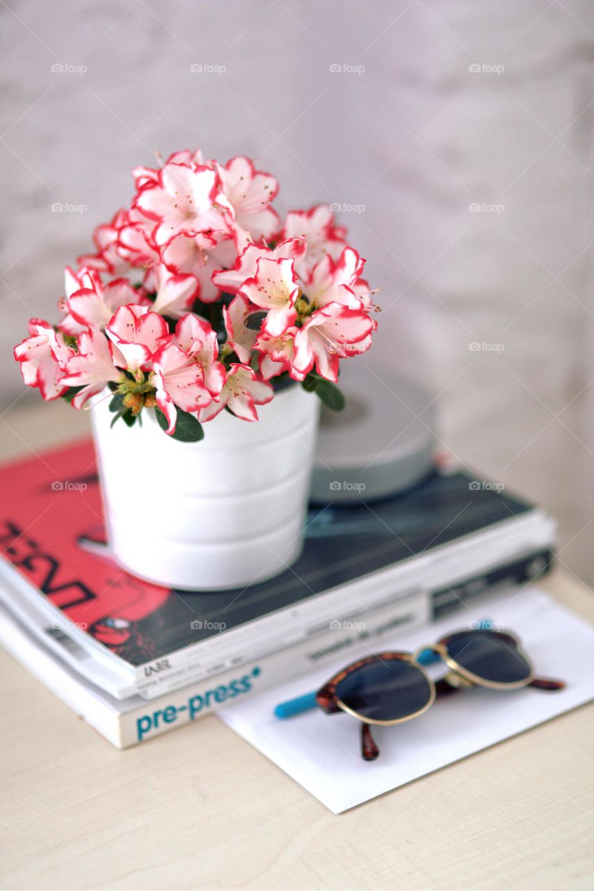 Magazines, flower and sunglasses on my office desk