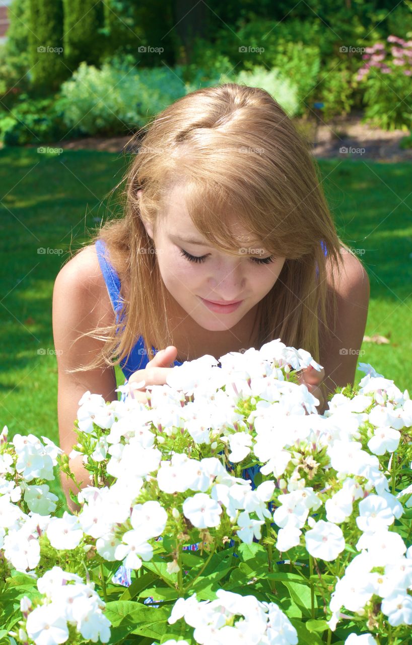 Front view of woman smelling flowers
