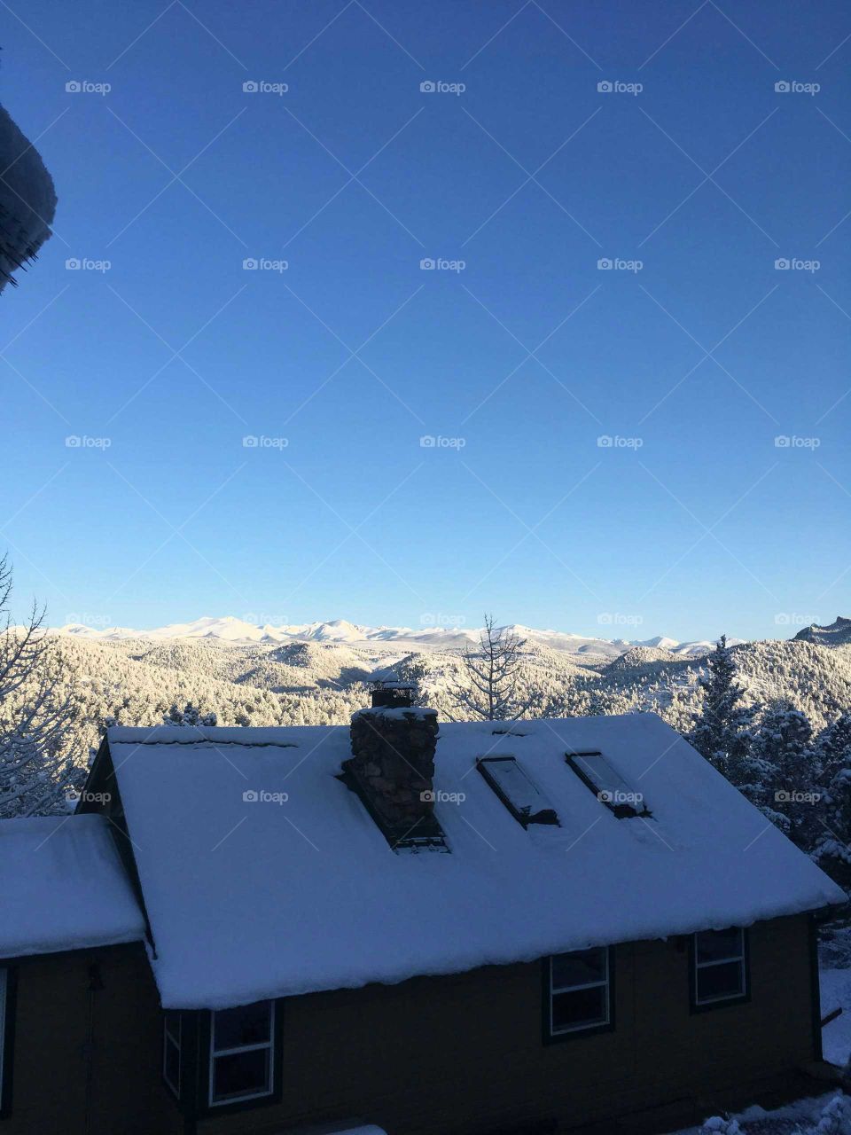 white snow on the house top an the the glaze of the beautiful blue sky