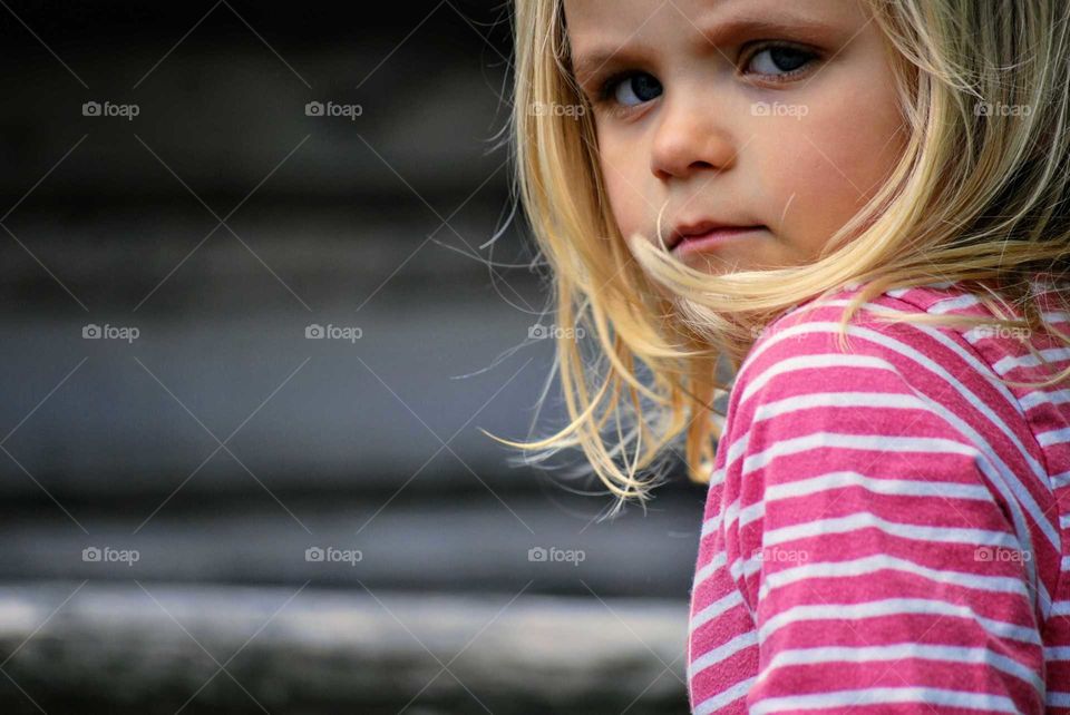 Girl standing on a wooden fence