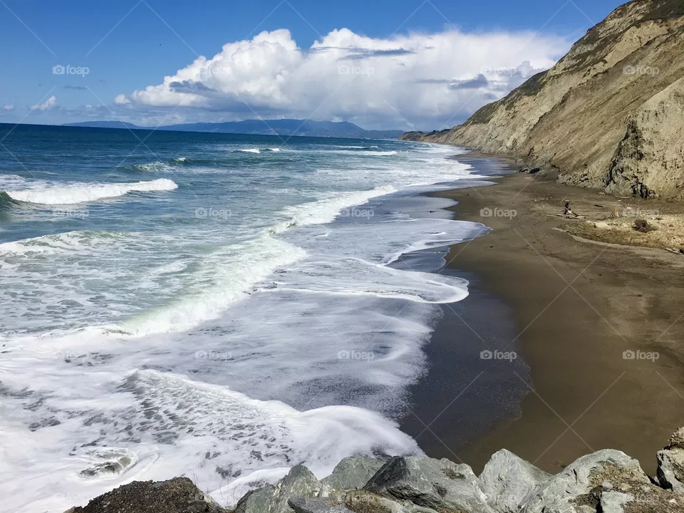 The waves washing the sand on the shore