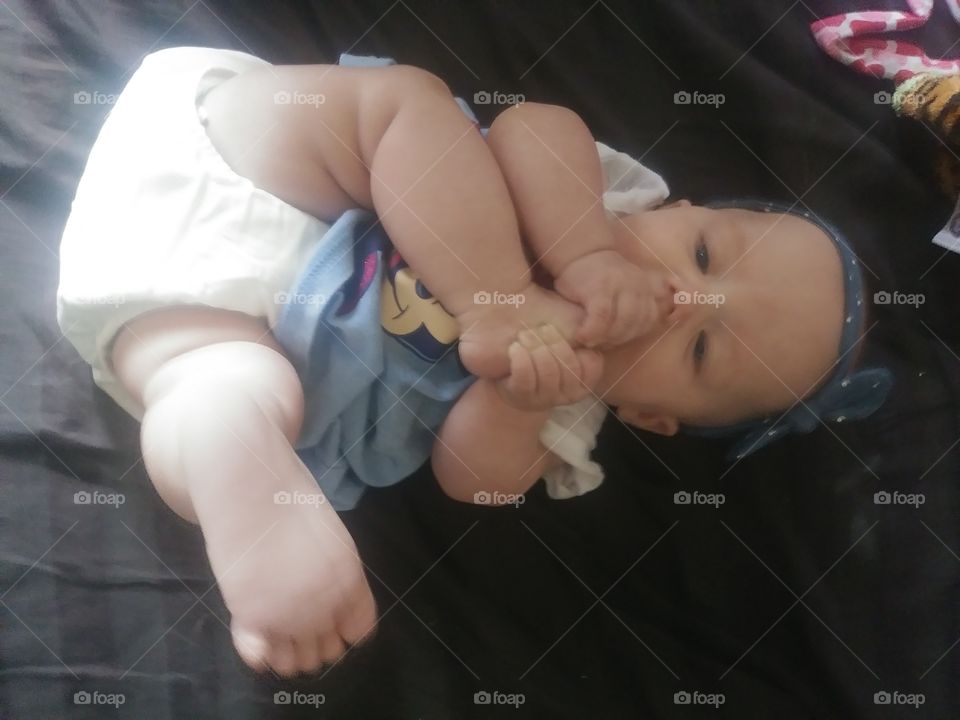 cute baby girl eating her toes so funny and adorable baby teething having fun