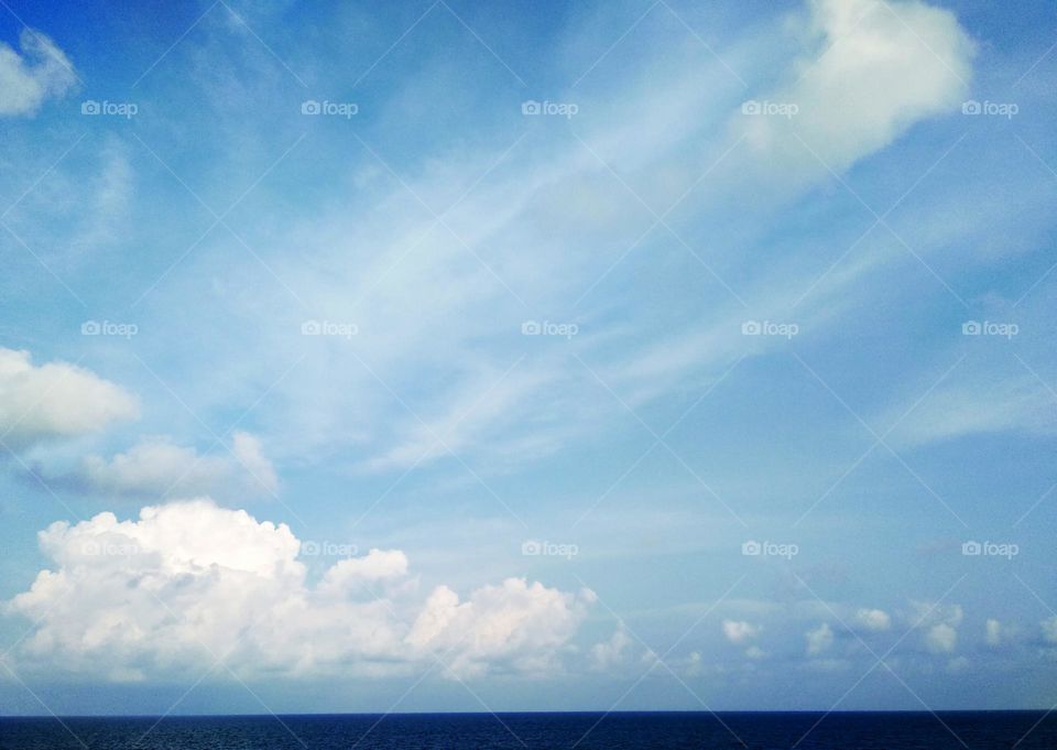 Cloudscape on the sea, abstract "fist" by cirrostratus clouds in clear sky.