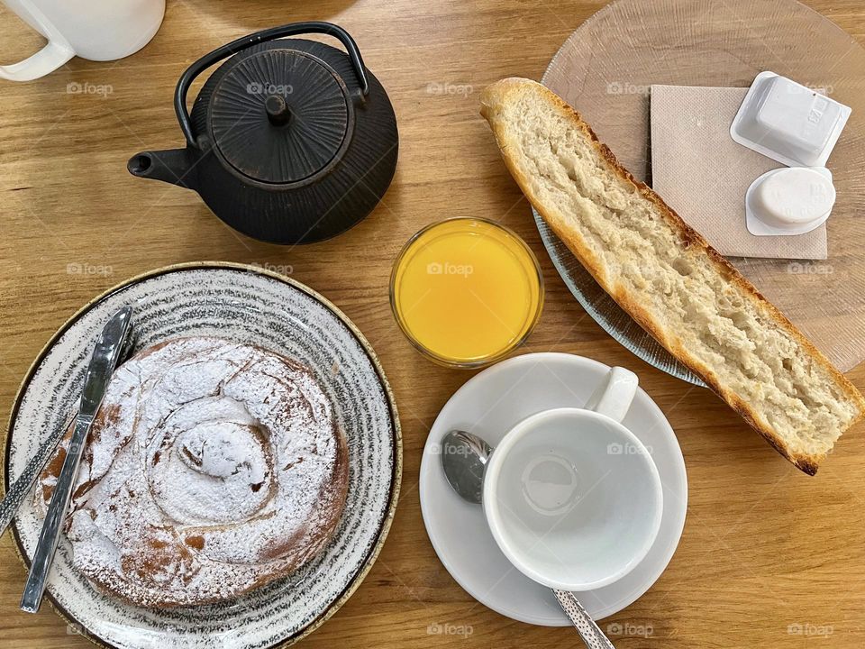 Typical Spanish breakfast from above, ensaimada, toasted bread, tea and orange juice 