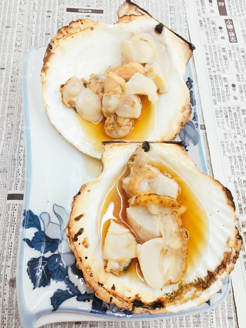 Grilled scallop in the shell on tray