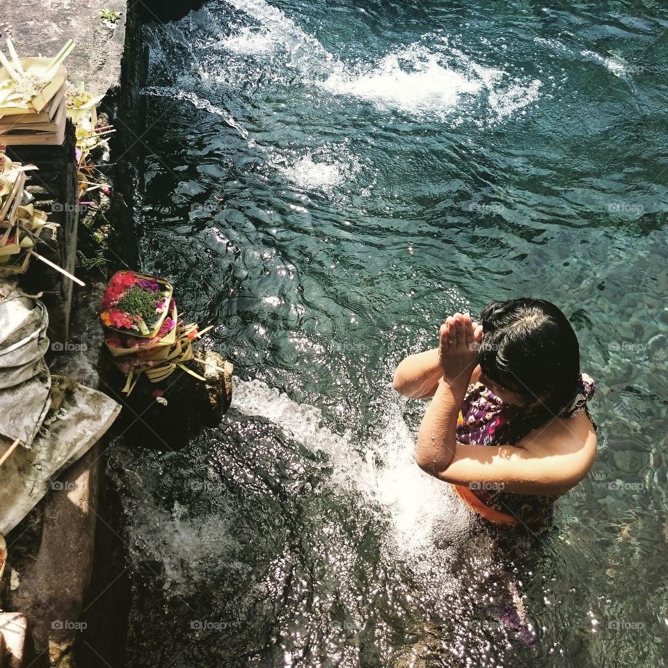 the prayer . one of a temple in Bali known has a Holy water which bring into 14 fountains. people prayed and cleanse their sins, while prayer in the pool