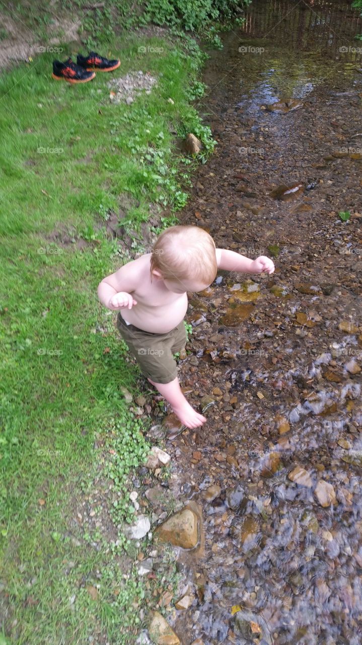 creek playtime. little boy playing in the stream