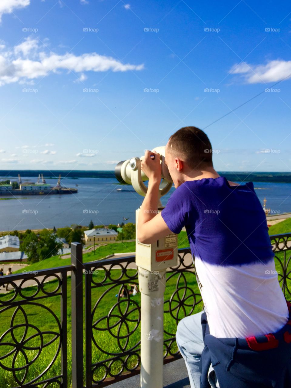 young man looking through binoculars at the beautiful view