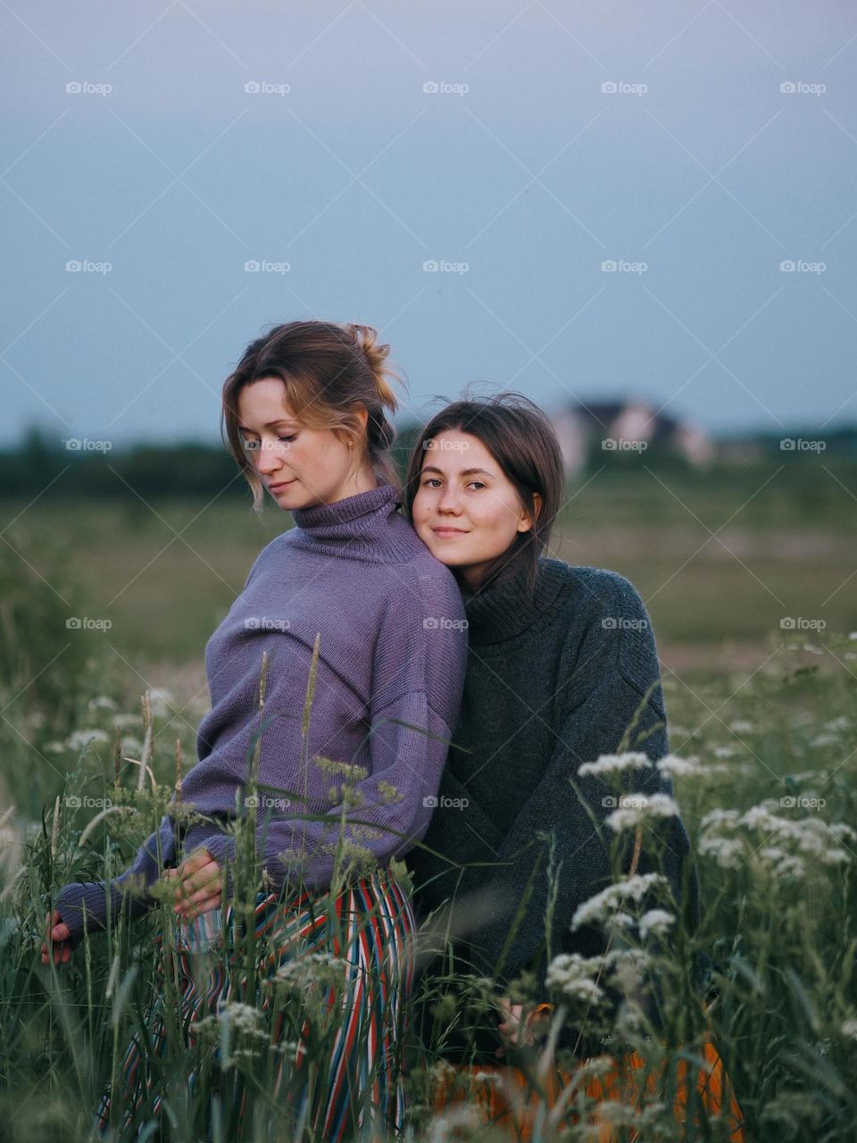 Two young beautiful woman’s standing in field on a summer day, portrait of woman 