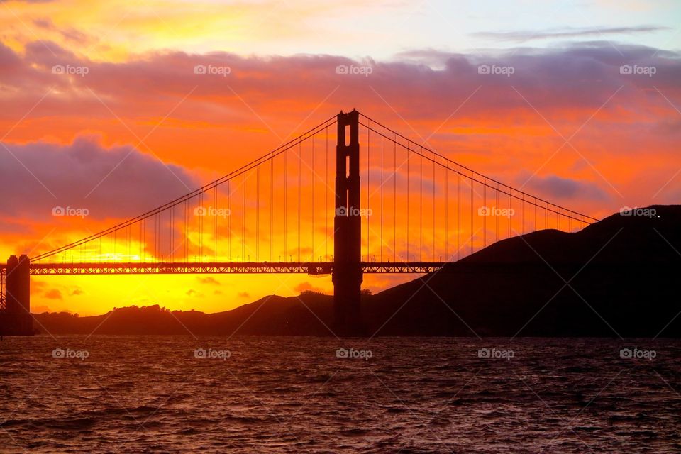 A colorful silhouetted sunset over the iconic Golden Gate suspension bridge in San Francisco, CA. 