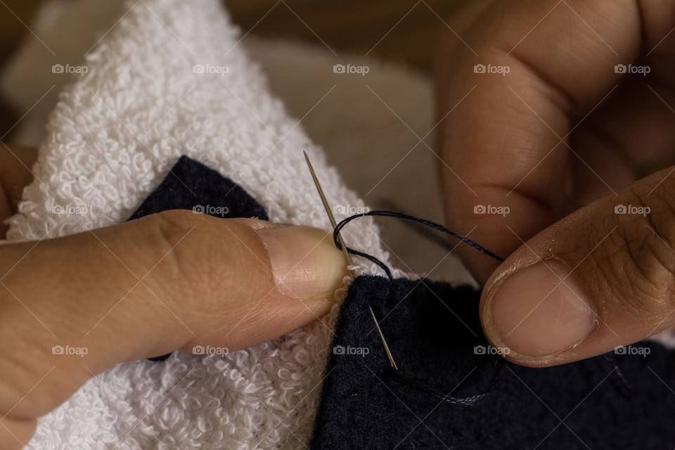 woman sewing with needle and thread