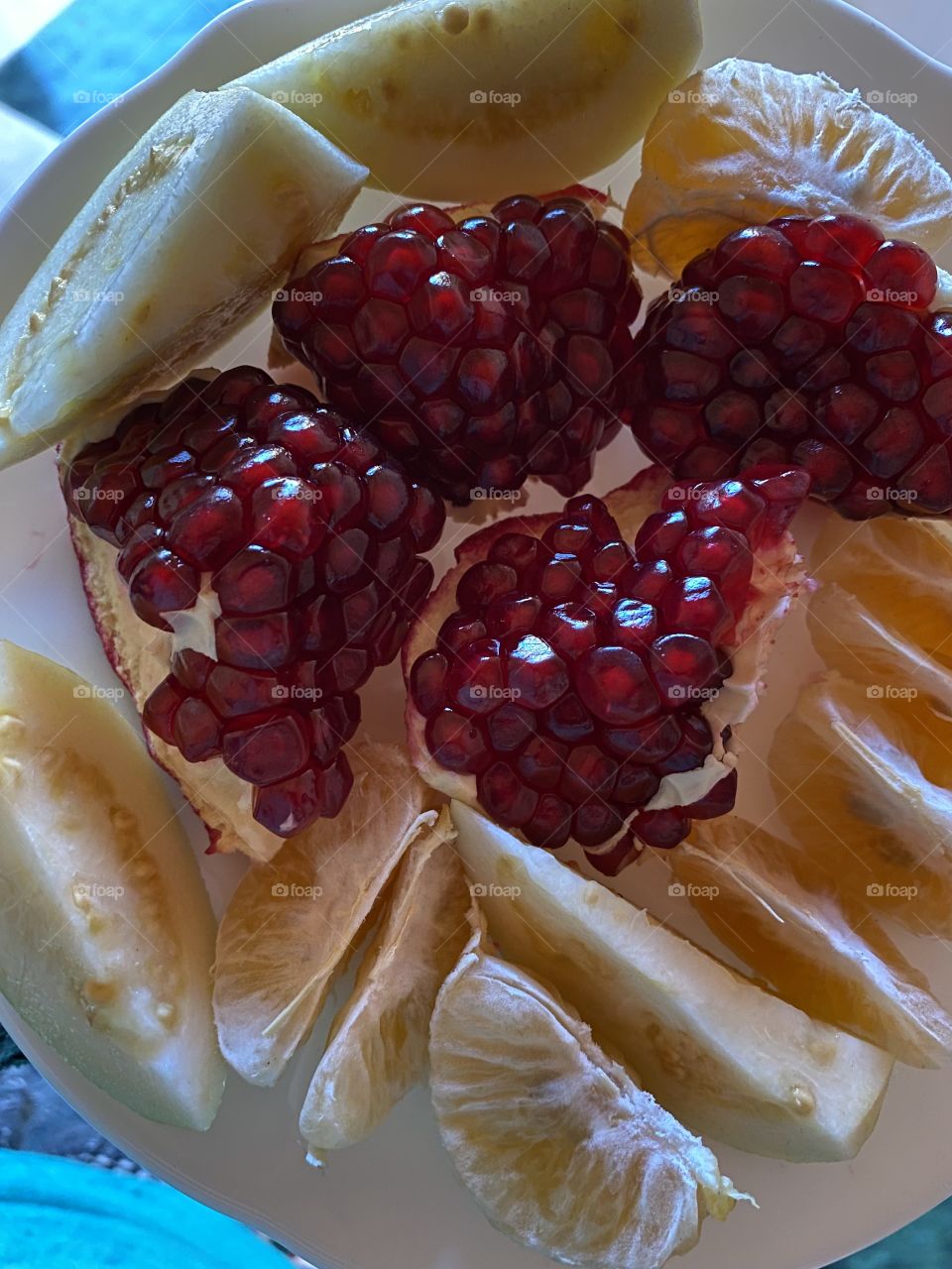 Pomegranate and other fruit on a white plate