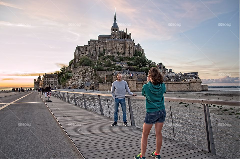 Young girl taking a photo in front of Mont Saint Michel 