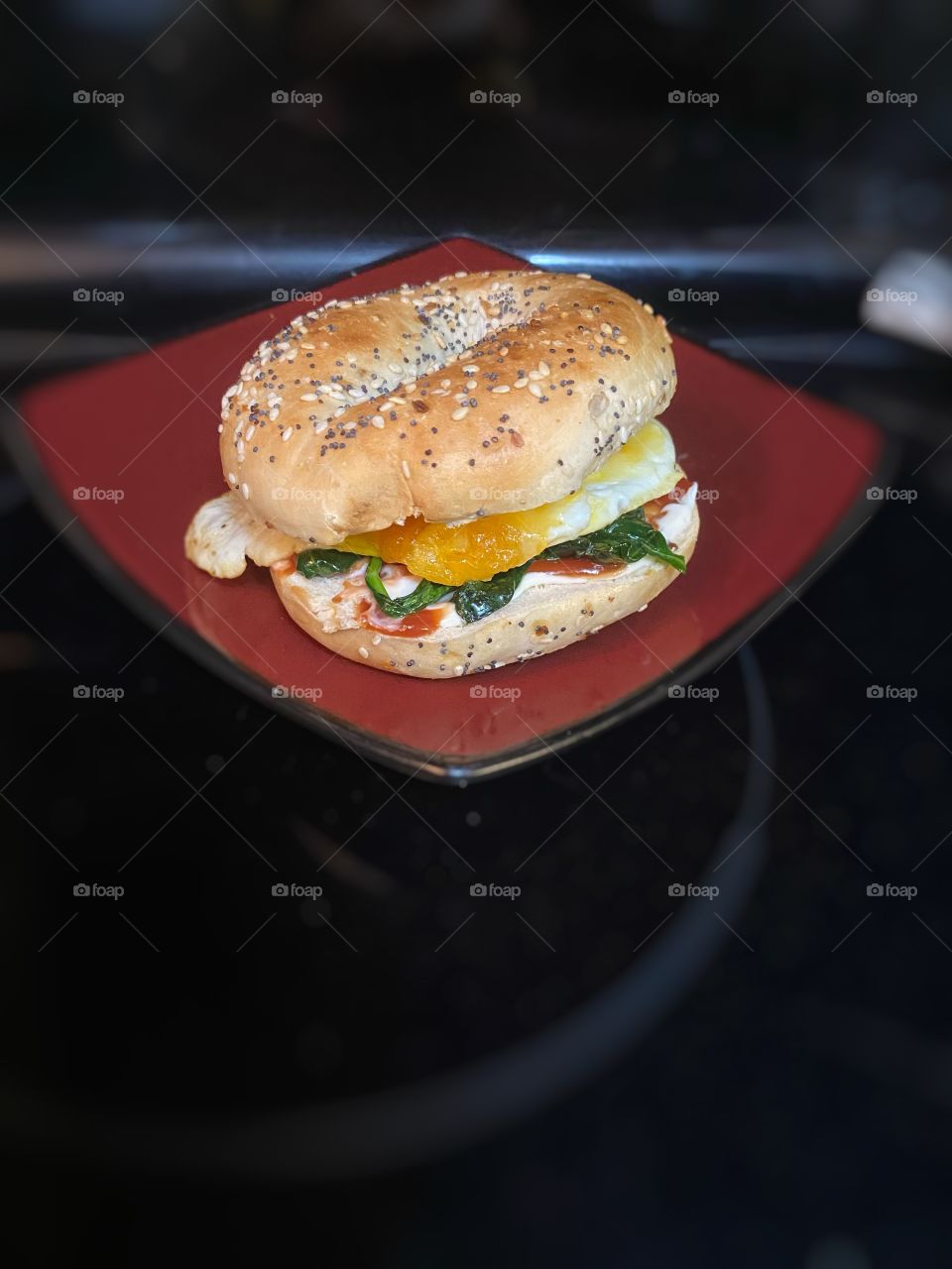 Breakfast Sandwich on Everything Bagel on a Red Plate