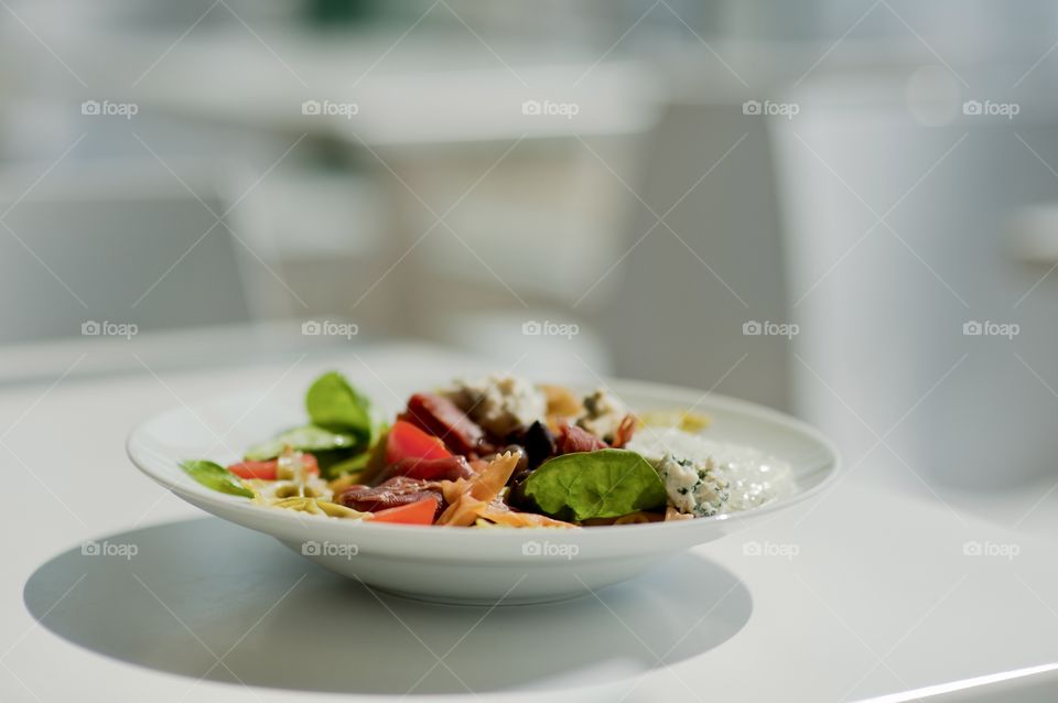 close-up of a young man eating a salad in a light kitchen