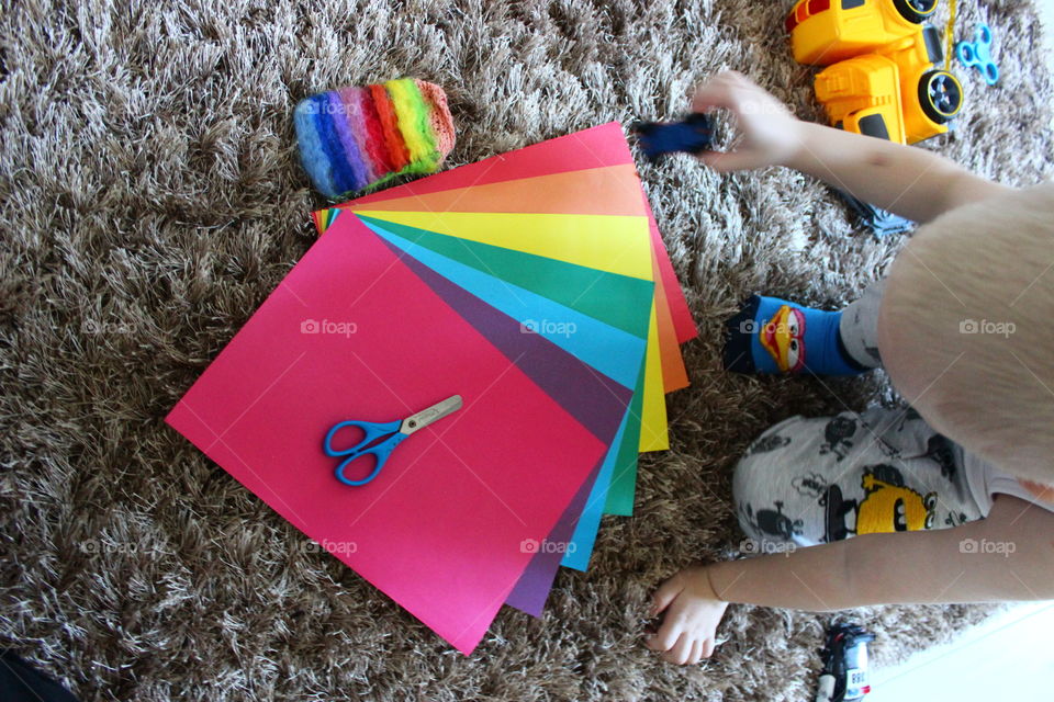 child sit on the floor colours paper seasors case