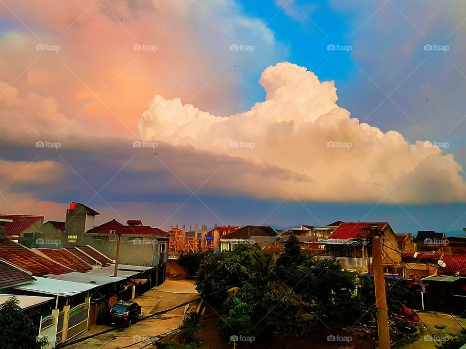 View of the sky clouds in the afternoon, the sky refracts bue, white clouds and yellowish red, some dark clouds, the atmosphere ia getting dark