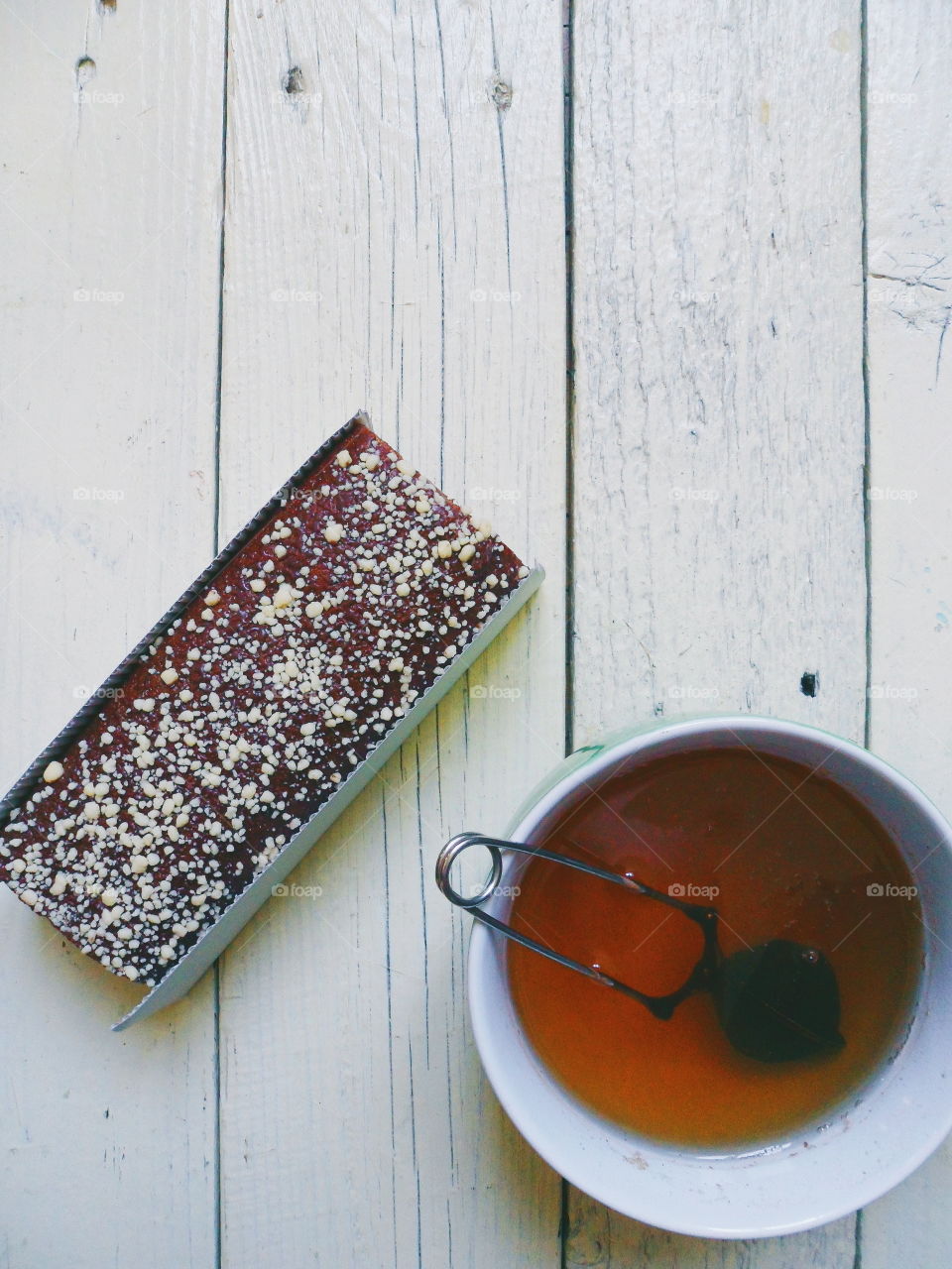 chocolate roll and a cup of black tea on a white background