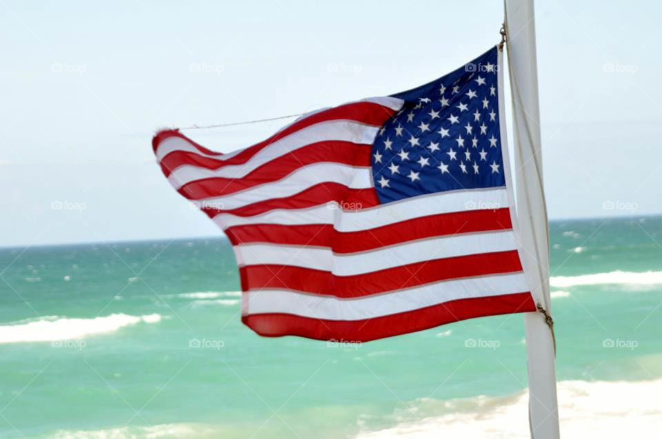American flag. American flag waving over the ocean