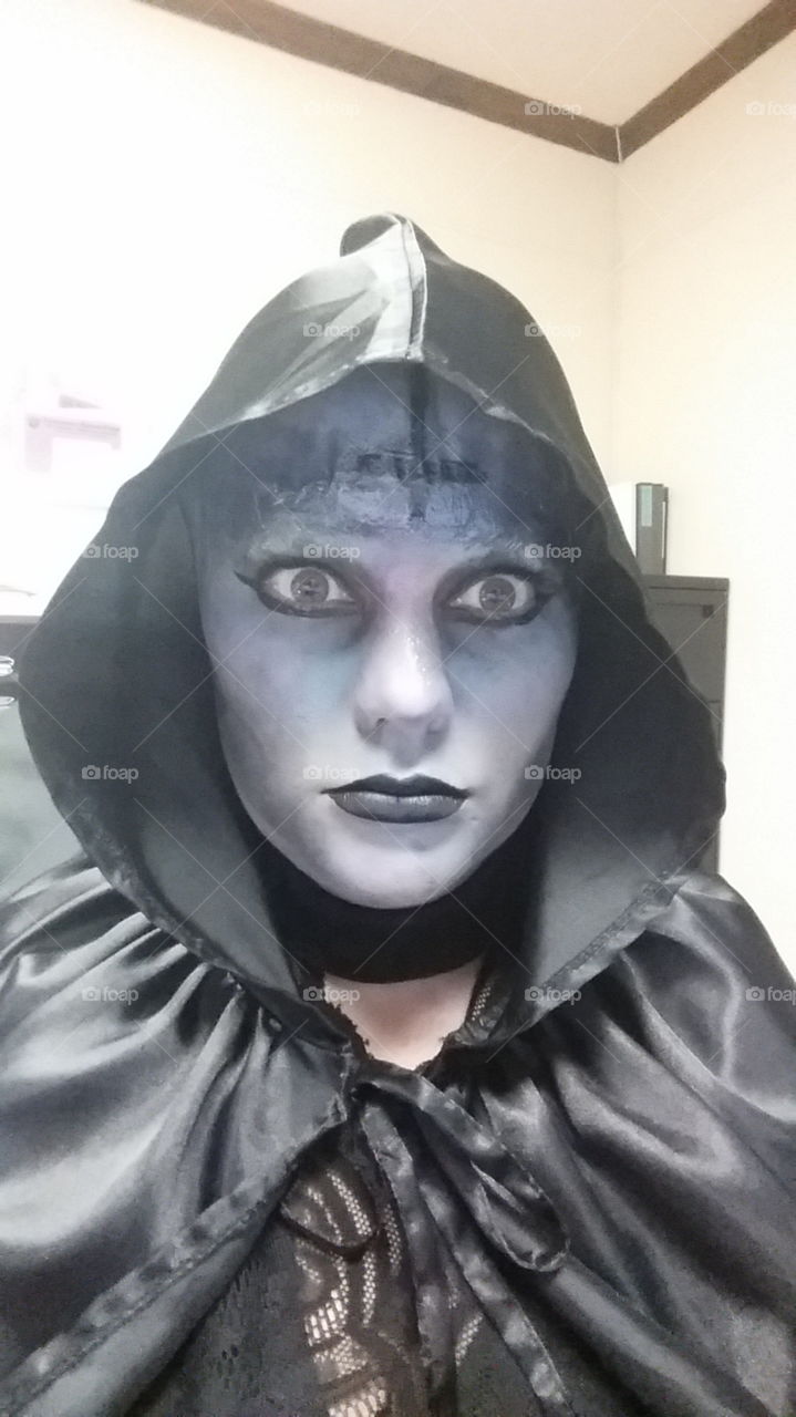 Scary woman in black hooded cloak