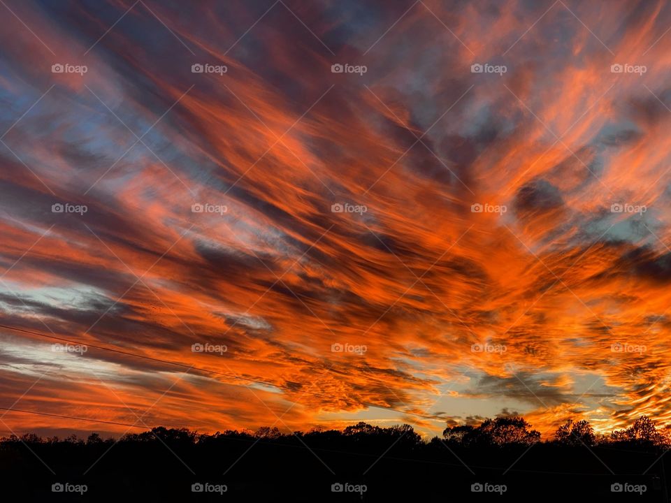 An exquisite mid west prairie sunset shot with vivid crimson red tones accompanied by breathtaking cloudscape.