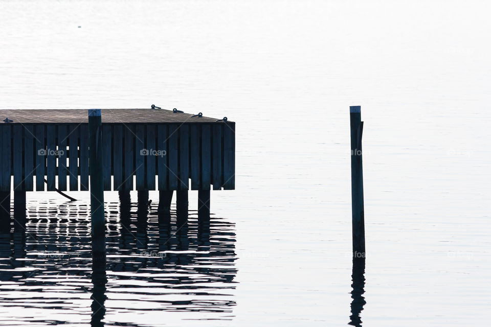 Reflection of wooden pier in the ocean 