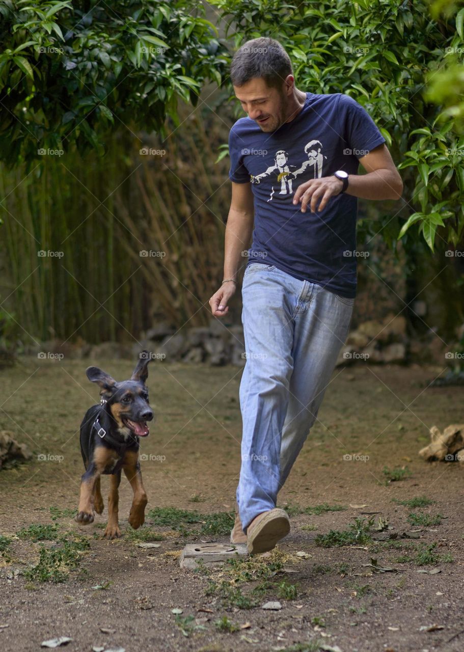 Young man running with his puppy 