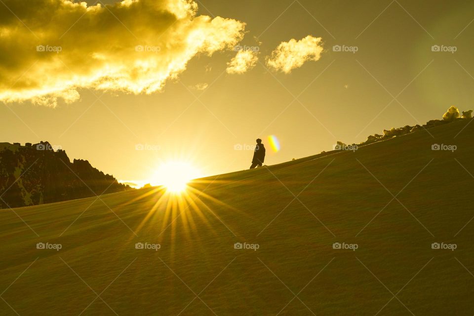 silhouette of single man enjoying the golden clouds