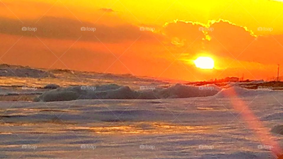 sunset on the Bolivar peninsula at Crystal Beach and Southeast Texas United States of America 2017. foamy waves on the beach and the sand