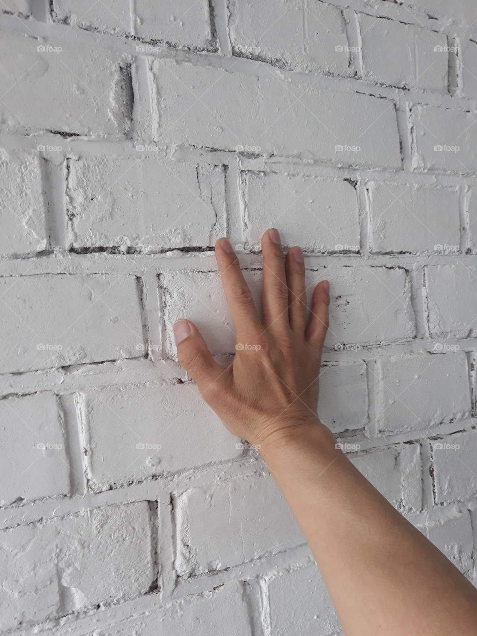 hand on a brick wall