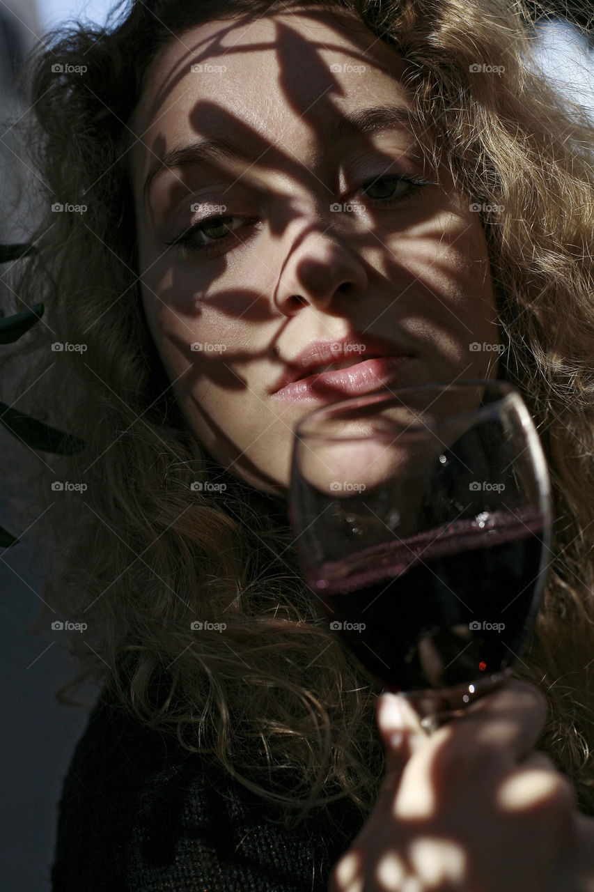 girl with glass of vine and the shado on her face