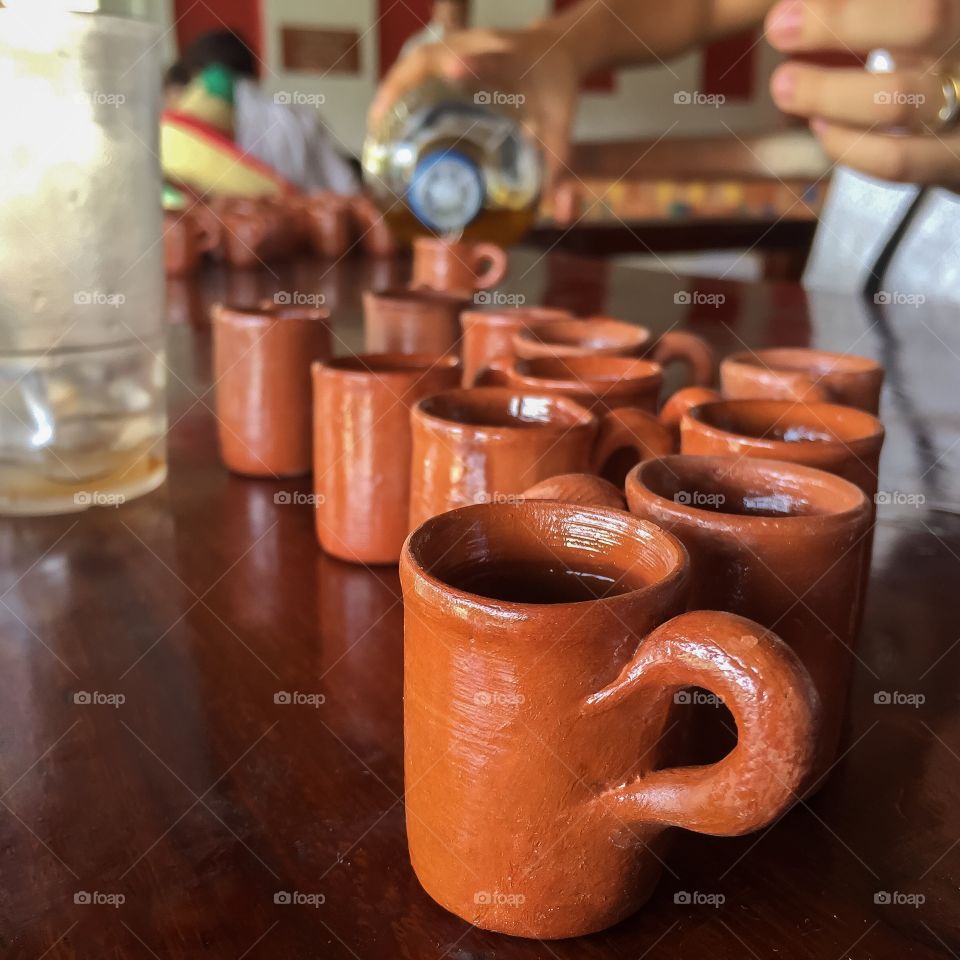 Person pouring tequila in cup