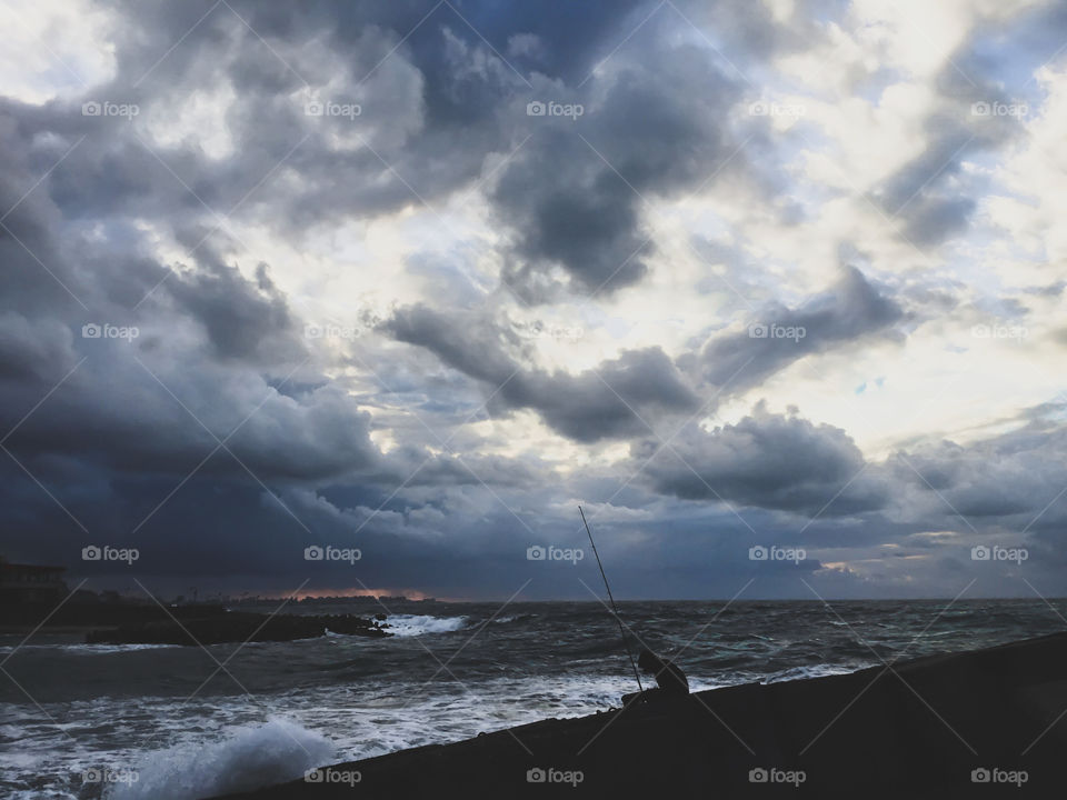 A fisherman working during a cloudy day in Alexandria, Egypt