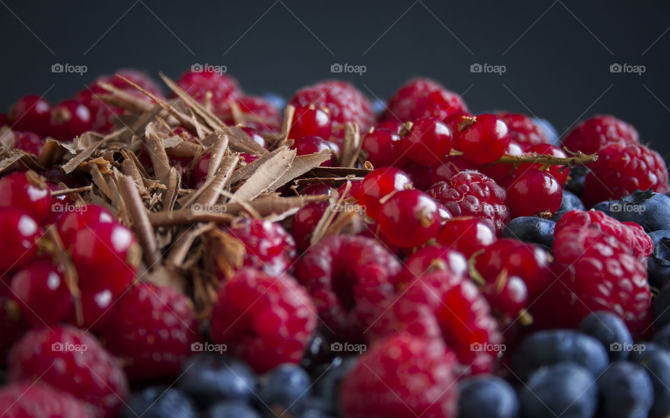 Summer berries and chocolate. Close up of Summer berries (raspberries, strawberries, red currants, blueberries) and chocolate curls on top of cake