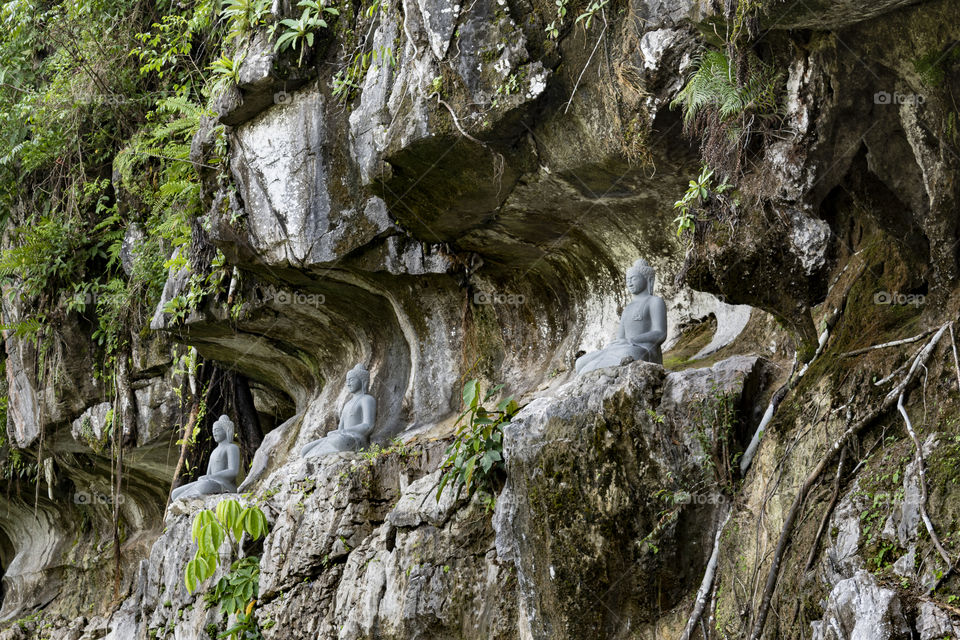 Buddha statues sitting by the mountain cliff