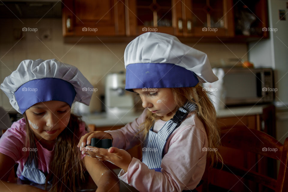 Little sisters cooking the biscuits 