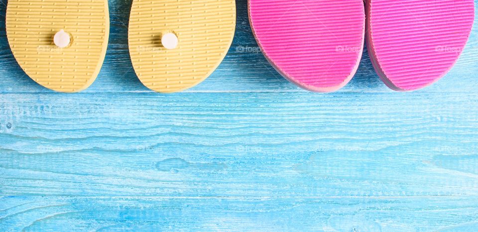 Summer beach slippers on a wooden background.