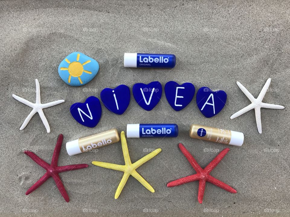 Nivea labels for everyone with colored starfishes and heart atones over the sand