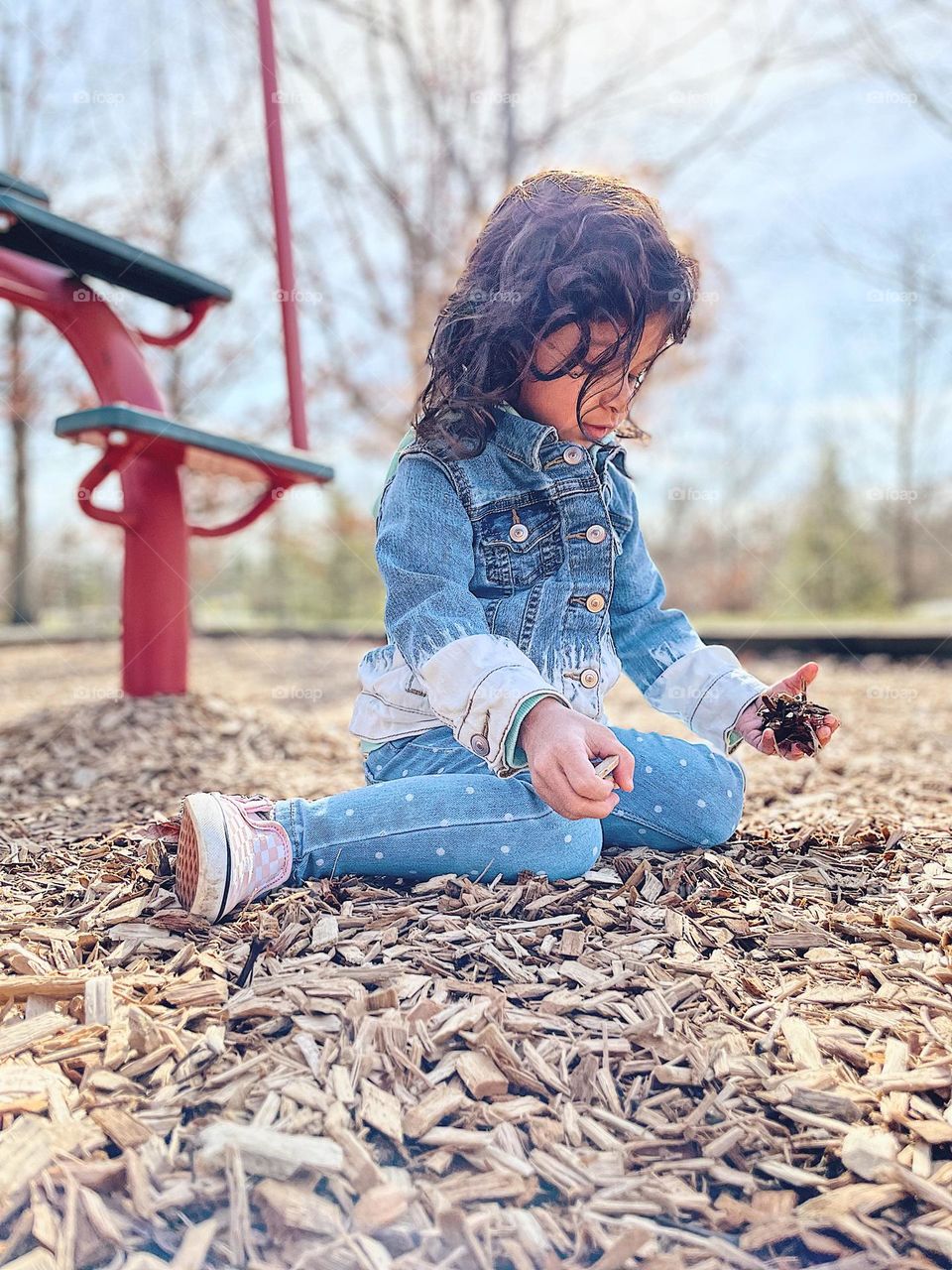 Toddler plays in the wood chips at the park, toddler girl having fun at the park, first signs of spring, having fun outside, children outside in the MidWest, Ohio kids having family time at parks, family time at the parks 