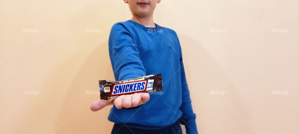 boy holding snickers in his hand