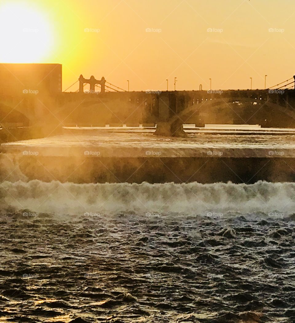 Overlooking Mississippi River from Stone Arch Bridge in Minneapolis. Beautiful waterfall with sun setting. 