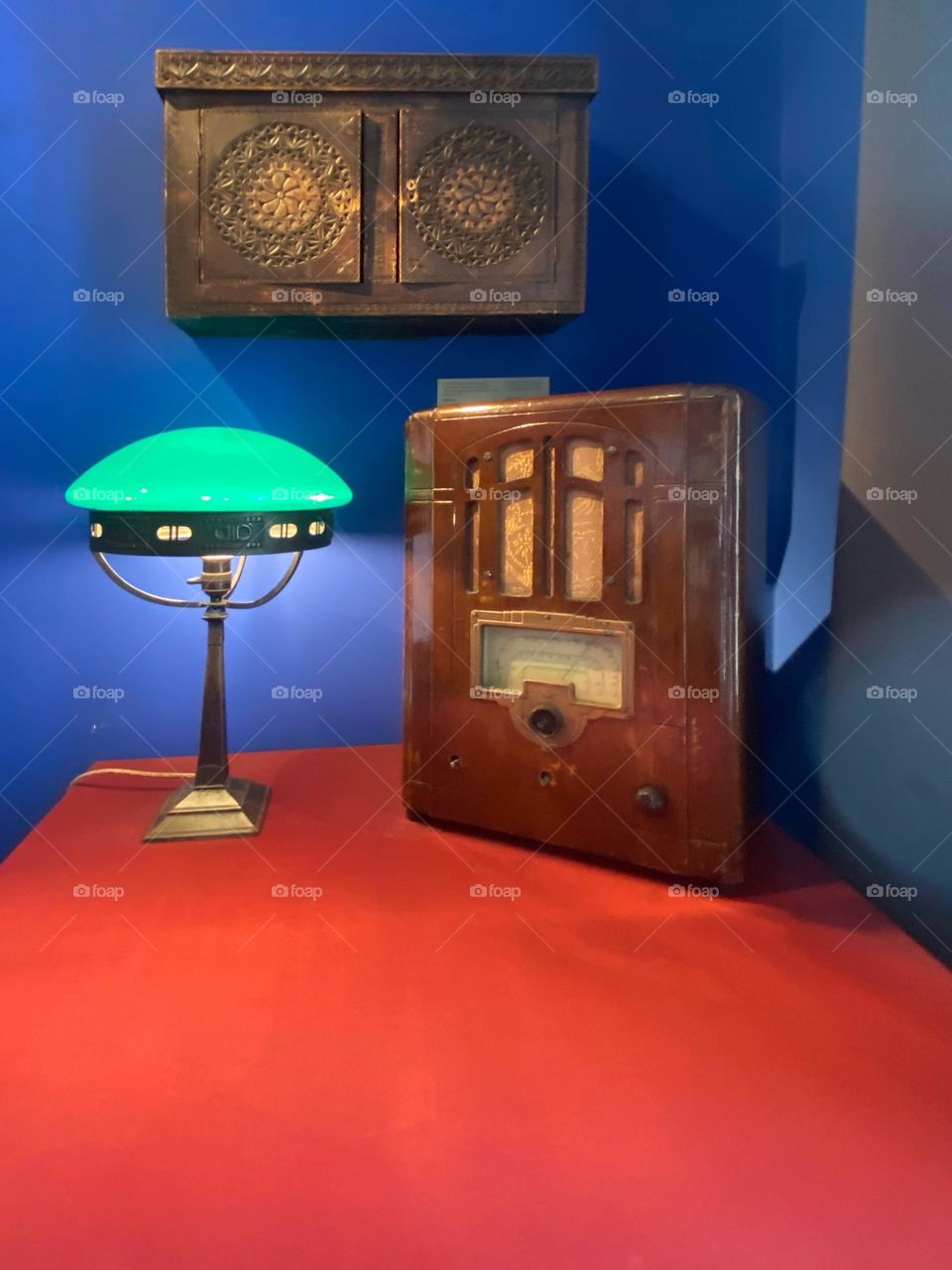 A desk lamp and an old radio on the table.