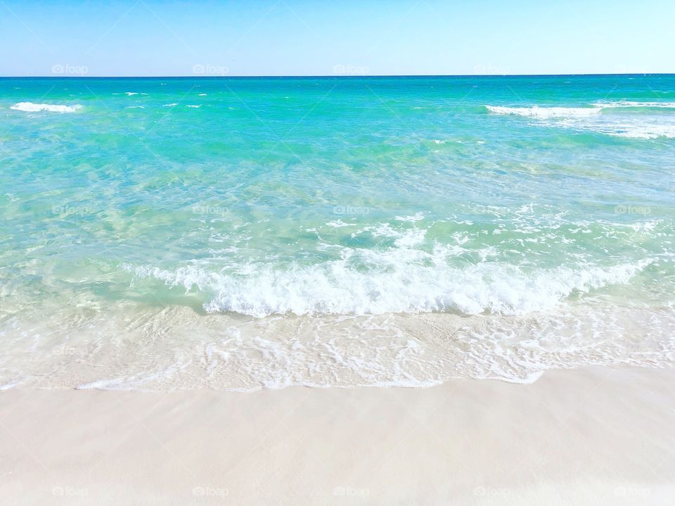 Emerald colored ocean and sugar white sand in Florida on a hot and bright Summer vacation