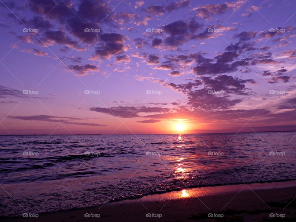 Color Purple - a magnificent mauve colored sunset reflecting off the rolling waves of the bay.  Purple pillow clouds dot the sky