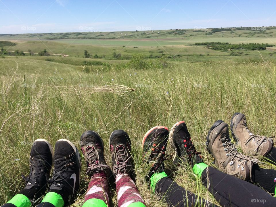 Hiking shoes and tick proof tape on top of a prairie hill. 