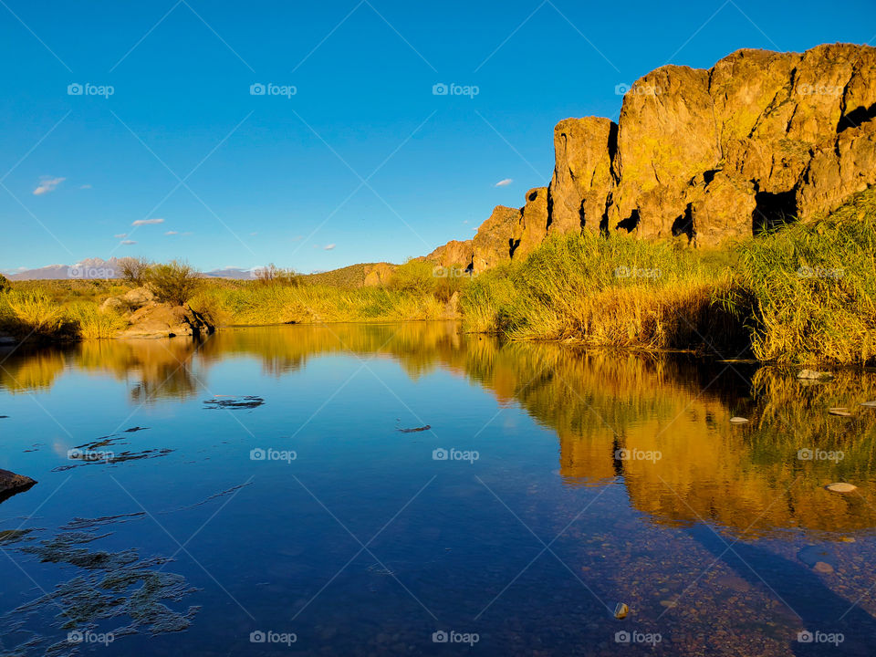 A reflection pond fed from the nearby Salt River mirrors a beautiful rock formation and spotless sky