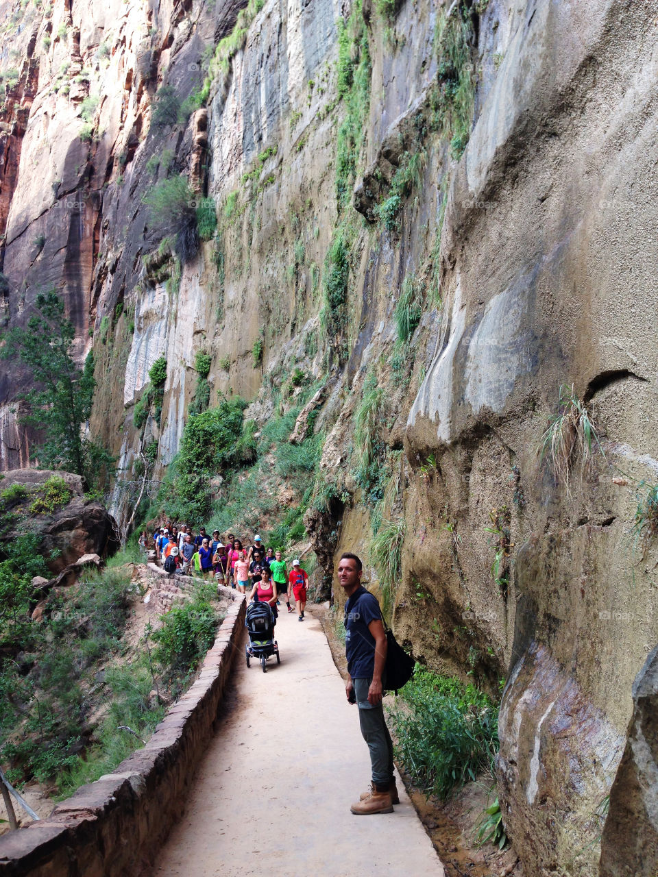 Tourist walking on walkway near rock formation