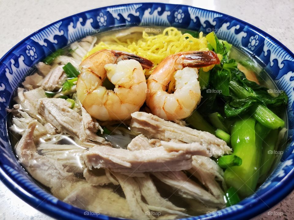 Lean shredded chicken meat and egg noodles in a healthy light broth. Garnished with green vegetables and topped with a couple of shrimps.