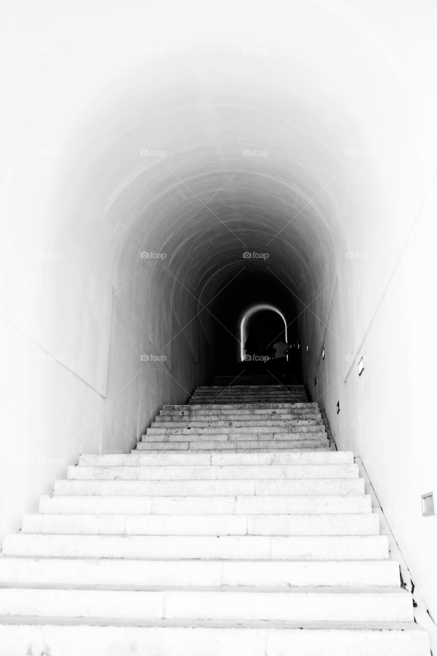 Light stone tunnel leading to the mausoleum of Petr Njegos in Montenegro.  A light in the end of a tunnel