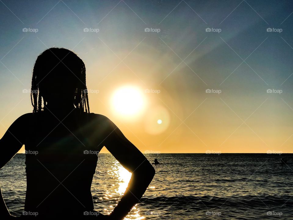 The silhouette of a girl on a beach at sunset